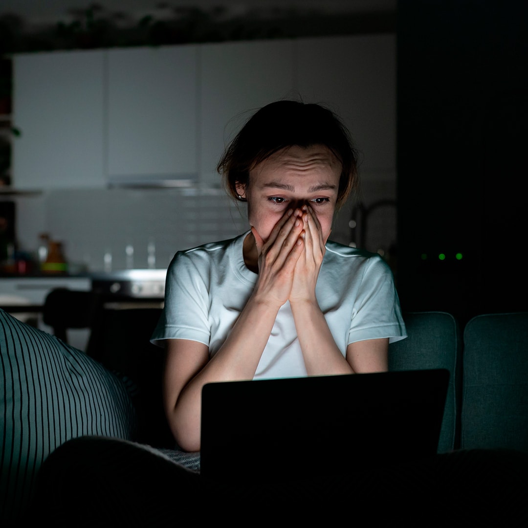 Ung kvinde sidder ved computer og googler angstsymptomer.