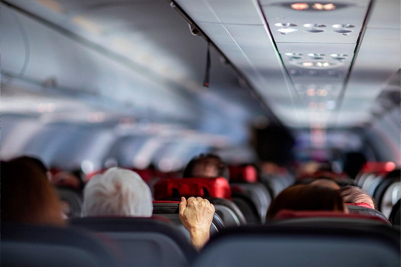 I en fly kabine tager mand fat i sædet da han er bange.